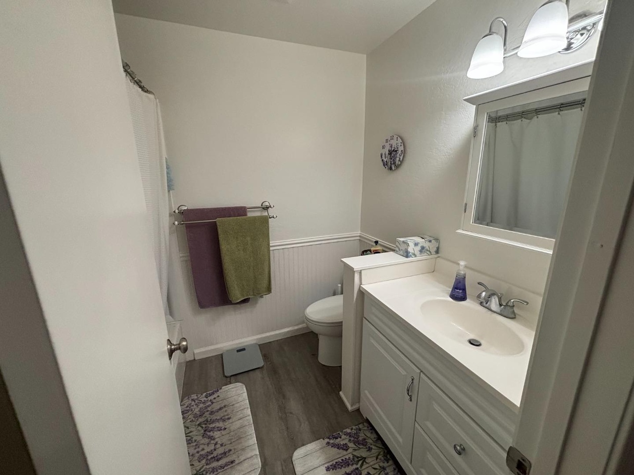 Updated bathroom with white vanity and shower over tub